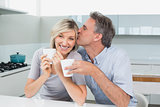 Loving couple with coffee cups in kitchen