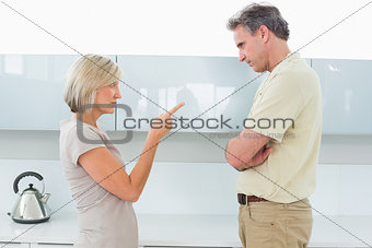 Angry couple arguing in kitchen