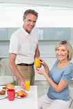 Happy couple having breakfast in kitchen