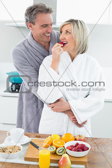 Man embracing a woman from behind in kitchen