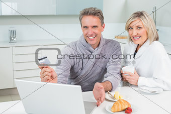 Couple doing online shopping in kitchen