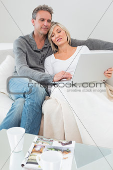 Couple using laptop in the living room