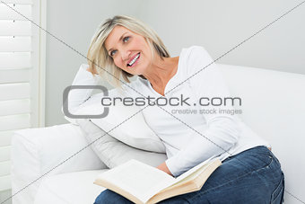 Happy woman with a book at home