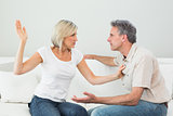Angry woman about to slap a man at home