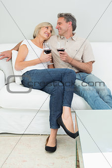 Relaxed couple with wine glasses at home