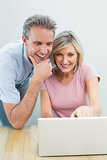 Casual couple using laptop at home