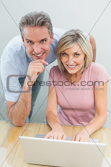 Content couple using laptop at home