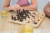 Mid section of a woman and man playing chess