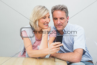 Happy couple looking at mobile phone
