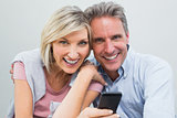 Cheerful couple with mobile phone