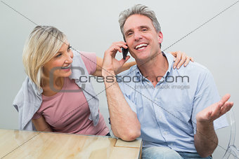 Happy casual couple using mobile phone