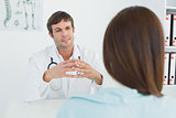 Doctor listening to patient with concentration in medical office