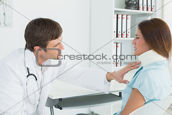 Doctor examining a patient's neck in medical office