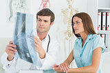 Male doctor explaining spinex-ray to female patient