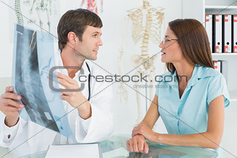 Male doctor explaining spine x-ray to female patient