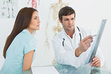 Doctor explaining x-ray to female patient in the medical office
