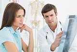 Male doctor explaining spine x-ray to female patient