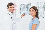 Smiling male doctor explaining lungs x-ray to female patient