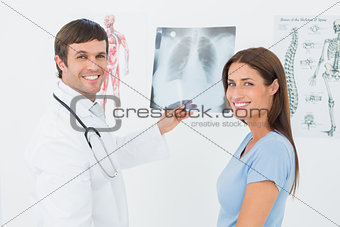 Smiling male doctor explaining lungs x-ray to female patient