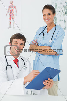 Smiling male doctor and nurse with reports