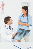 Male doctor and female surgeon examining x-ray