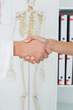 Extreme close-up of a doctor and patient shaking hands