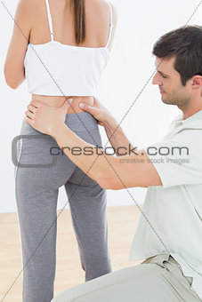 Rear view of a physiotherapist examining woman's back