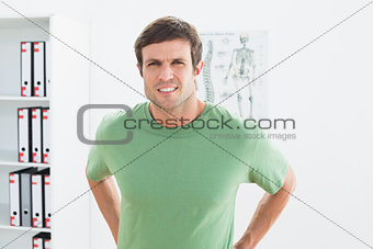 Portrait of a handsome young man with back pain