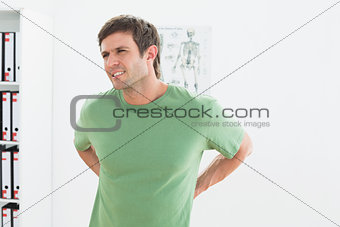 Portrait of a handsome young man with back pain