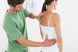 Male physiotherapist examining woman's back
