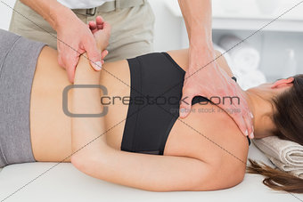 Male physiotherapist massaging woman's body