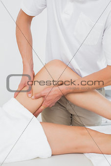 Male physiotherapist examining a woman's leg