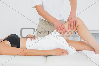 Physiotherapist examining a young woman's leg