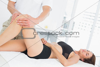 Male physiotherapist examining a young woman's leg