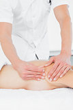 Mid section of a physiotherapist massaging woman's body