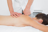 Close-up of a physiotherapist massaging woman's back
