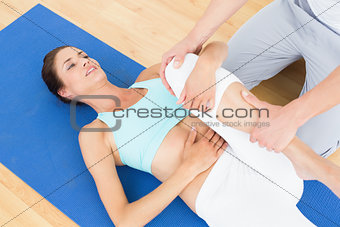 Physical therapist examining young woman's leg