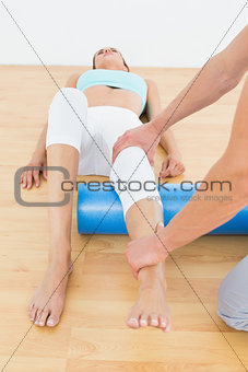 Physical therapist examining a young woman's leg