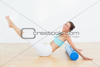 Toned woman doing the boat pose in fitness studio