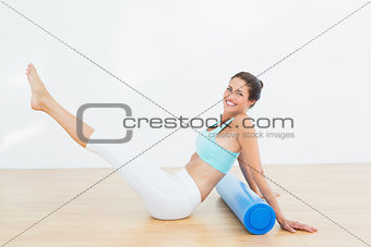 Toned woman doing the boat pose in fitness studio
