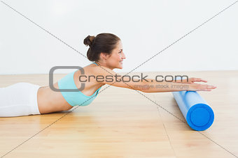 Toned woman doing the stretching exercise in fitness studio
