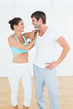 Fit cheerful couple in fitness studio