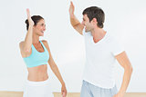 Cheerful fit young couple giving high five