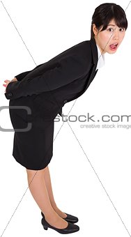 Surprised businesswoman bending