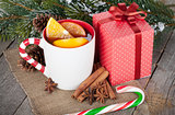 Christmas mulled wine with spices, gift box and snowy fir tree