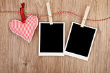 Blank instant photos and red heart hanging on the clothesline