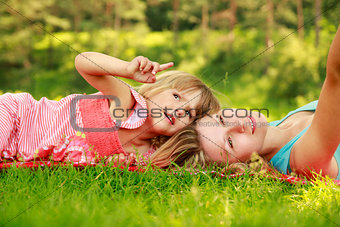 Mama and her little daughter on the grass 