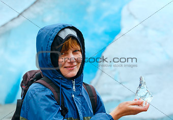 Woman with ice piece near Nigardsbreen glacier (Norway)
