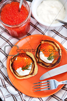 Pancakes with red caviar and sour cream