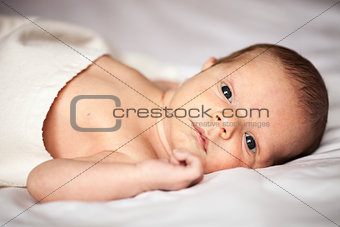 Cute newborn baby boy looking at camera